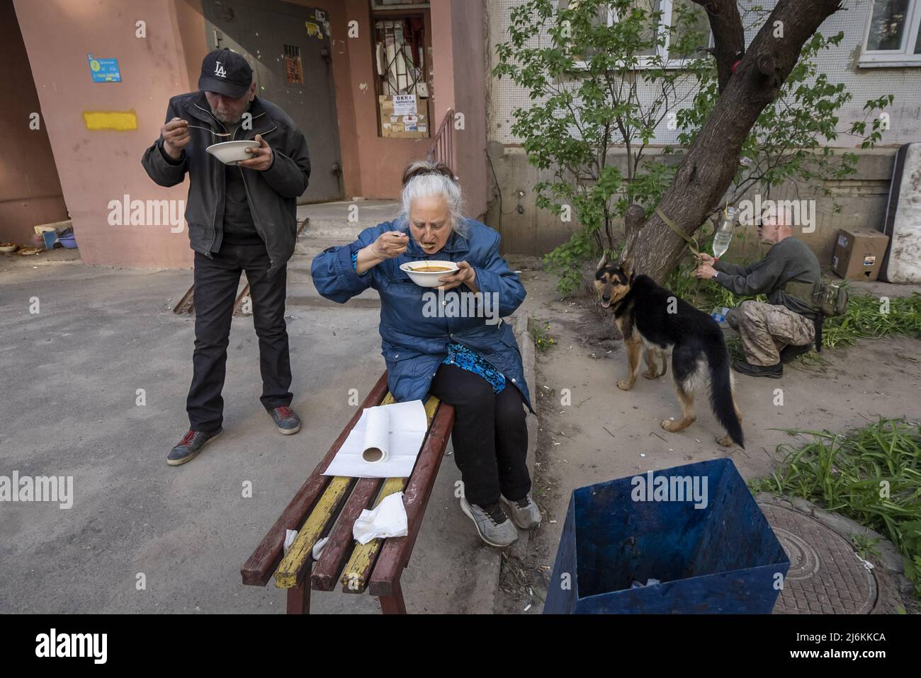 Kharkiv, Ukraine. 02nd May, 2022. Oleg Petyushenko, 46, left, and Lyudmyla Mikhailivna Kirichenko, 75, right, eat soup as Sasha Zolotov, 55, ties up his dog in front of their apartment building close to the Russian border in Kharkiv, Ukraine, Monday, May 2, 2022.  Top Israeli officials on Monday condemned remarks from Russia's chief diplomat that claimed that Nazi leader Adolf Hitler was Jewish and implied that Jewish captives during World War II were responsible for their own deaths in the Holocaust.  Photo by Ken Cedeno/UPI Credit: UPI/Alamy Live News Stock Photo