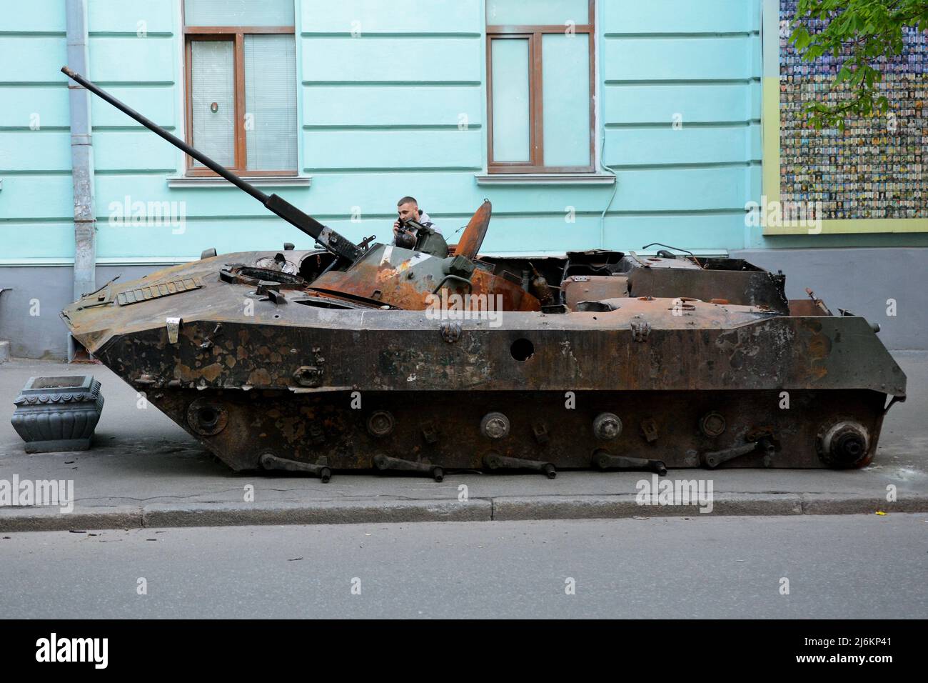 Kyiv region, Ukraine - 02 May 2022, A man examines a destroyed Russian tank parked on the roadside, it was destroyed by the Ukrainian military in the Kiev region. Russia invaded Ukraine on 24 February 2022, triggering the largest military attack in Europe since World War II. Stock Photo