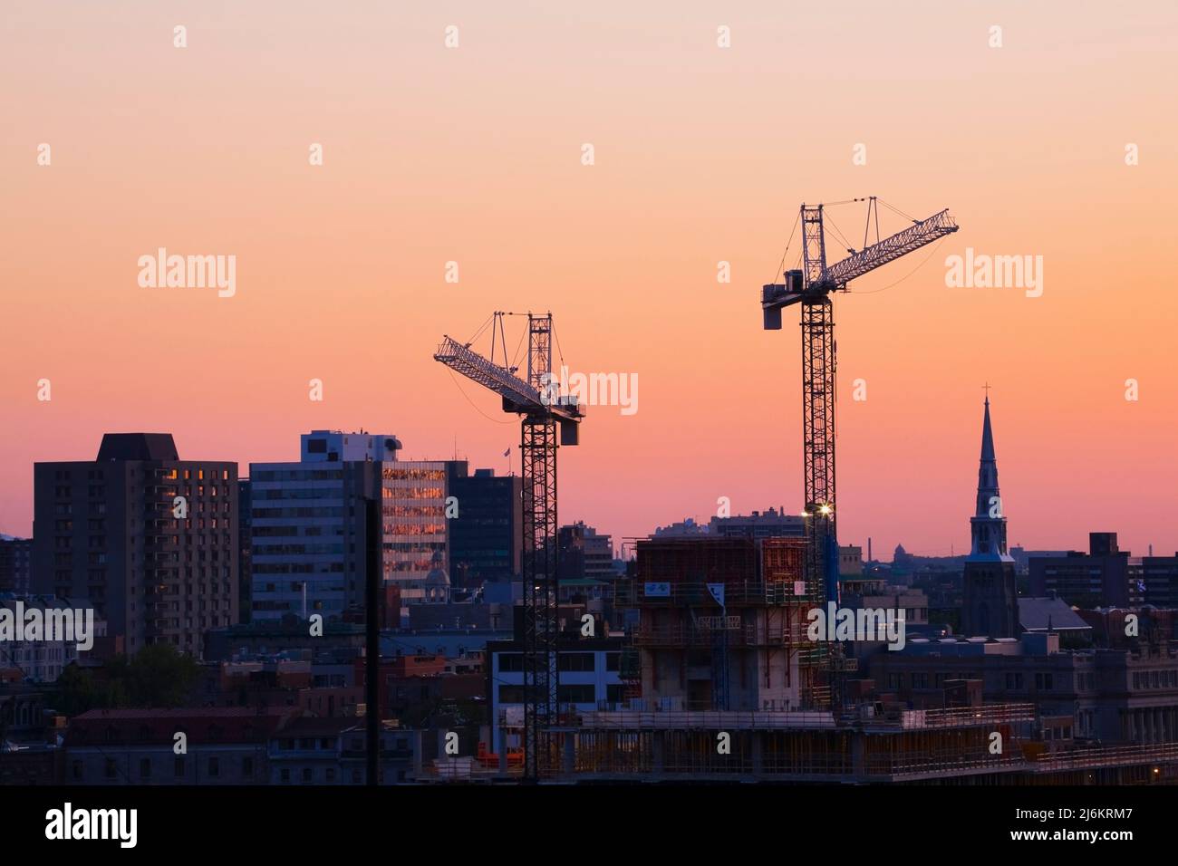 Construction work cranes towering over the Montreal skyline at dawn ...