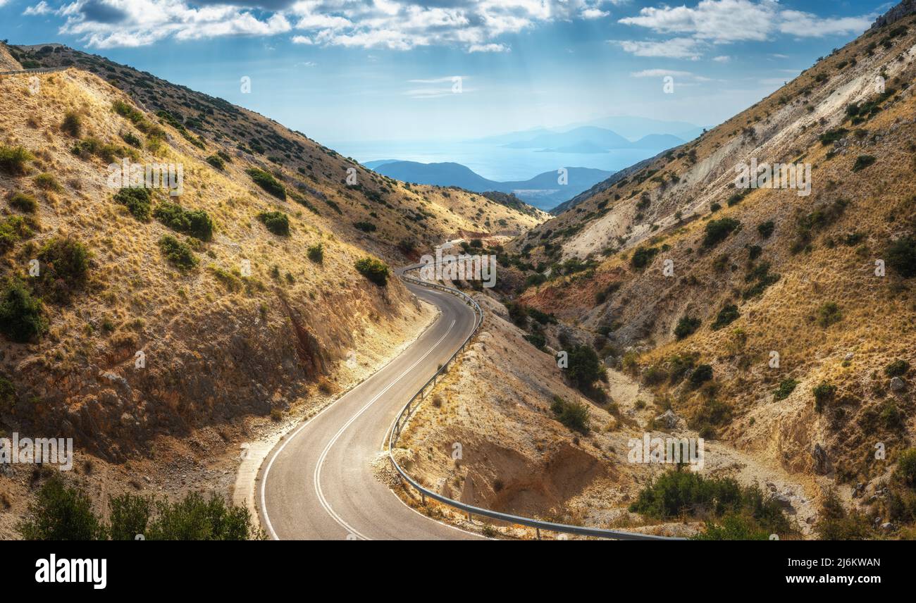 Aerial view of winding mountain road, blue sky at sunny day Stock Photo ...