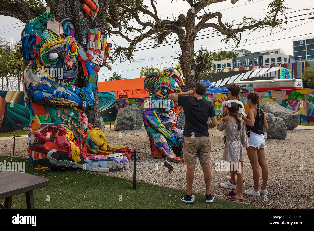 A family looks at the sculpture A Plastic Mom and Baby Monkeys by Artur Bordalo (Bordalo II) in Wynwood Walls, Wynwood, Miami, Florida, USA Stock Photo