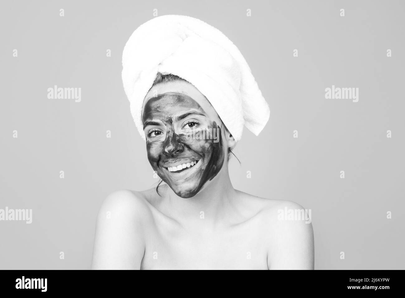 Mud facial mask, face clay mask spa. Beautiful smiling woman with ...