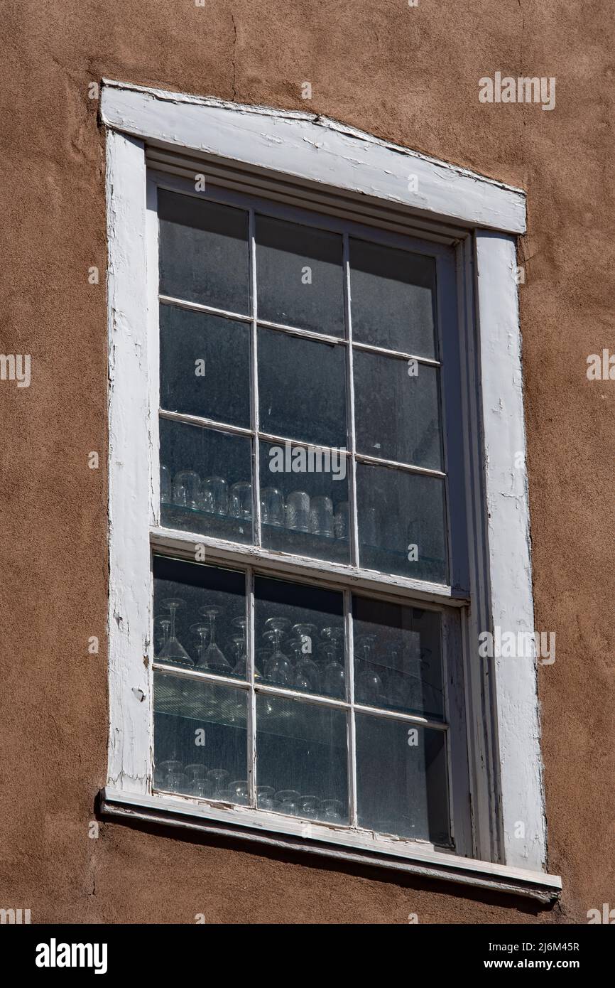 Glasses in window with white wooden framed  in adobe style home in Santa Fe New Mexico U.S.A. square shapes old window frame adobe style architecture Stock Photo