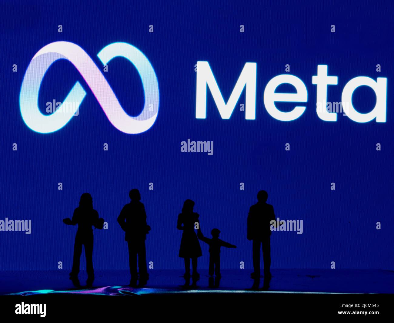 Miniature figures standing in front of a Meta Platforms Inc. logo on