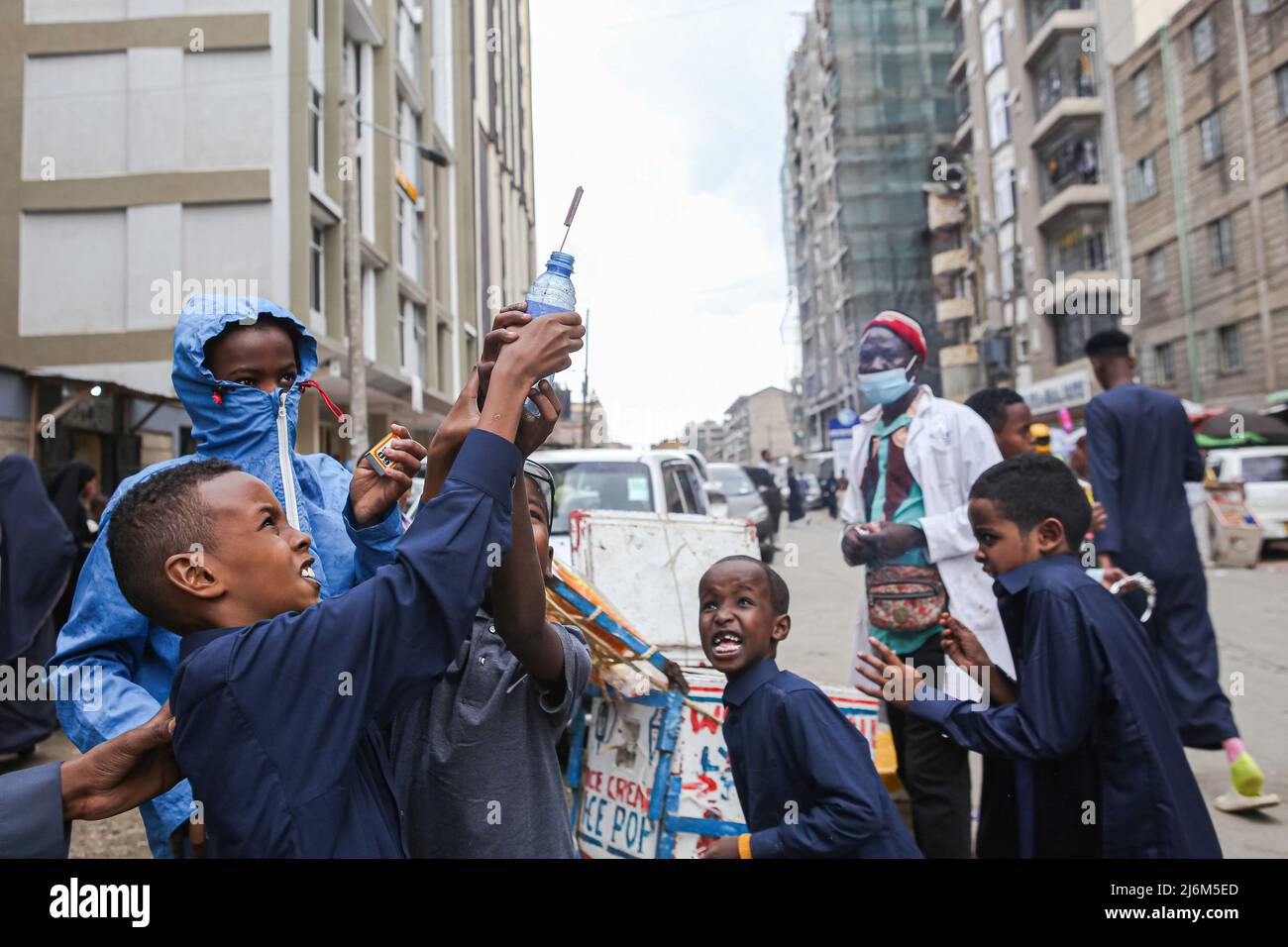 A Kenyan Somali boy points up fireworks after lighting at Jackson Muriethi street in Eastleigh, on Eid-Ul-Fitr. Muslims in Kenya celebrate Eid-Ul-Fitr which marks the end of the Holy month of Ramadhan. Stock Photo