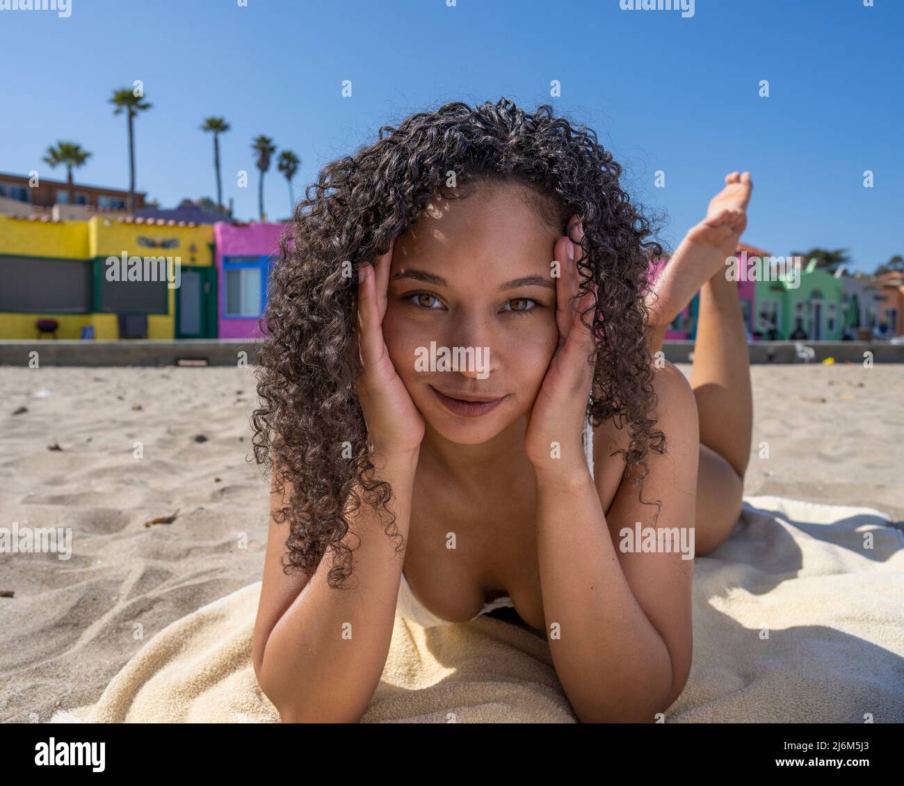 Young Woman in White Bikini Laying on the Sand at Capitola Beach Stock Photo