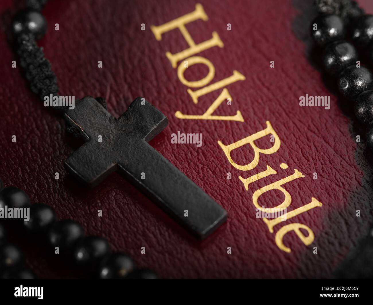 Macro shot. The book of the Holy Bible with a golden inscription and a Catholic cross on the rosary. Symbols of spirituality, Catholicism. Prayer, med Stock Photo