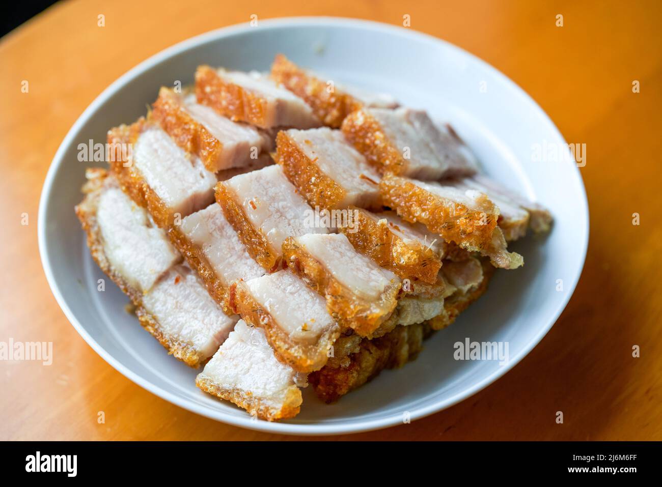 Close-up of a plate of golden and attractive crispy roasted pork, with meat Stock Photo
