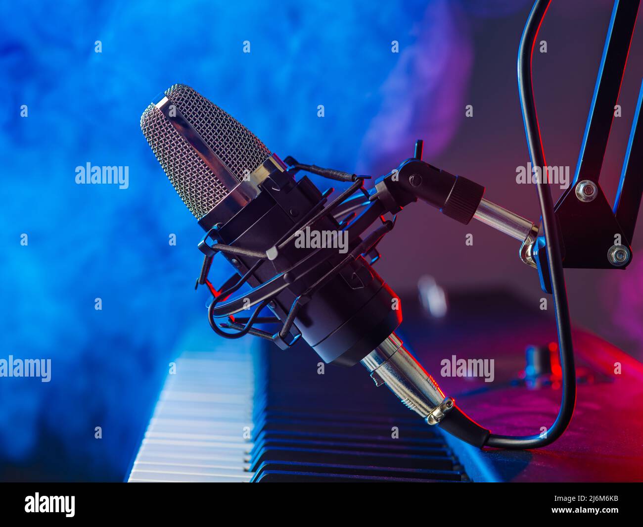 Professional microphone and midi keyboard on a snowy background. Neon