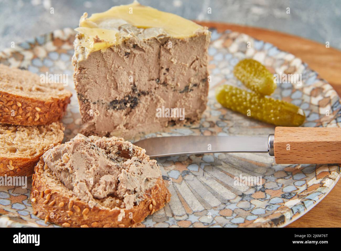 Chicken liver pate with truffles with bread knife and pickles Stock