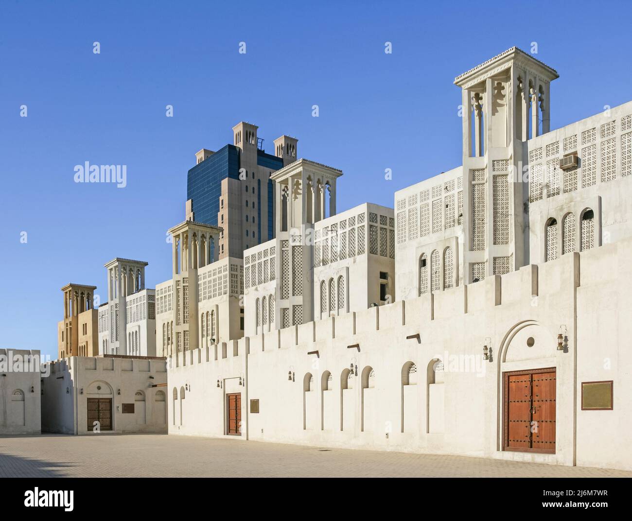 The city of Sharjah's restored Heritage Area in the United Arab Emirates, with a more modern Arabian-styled building in the background. Stock Photo