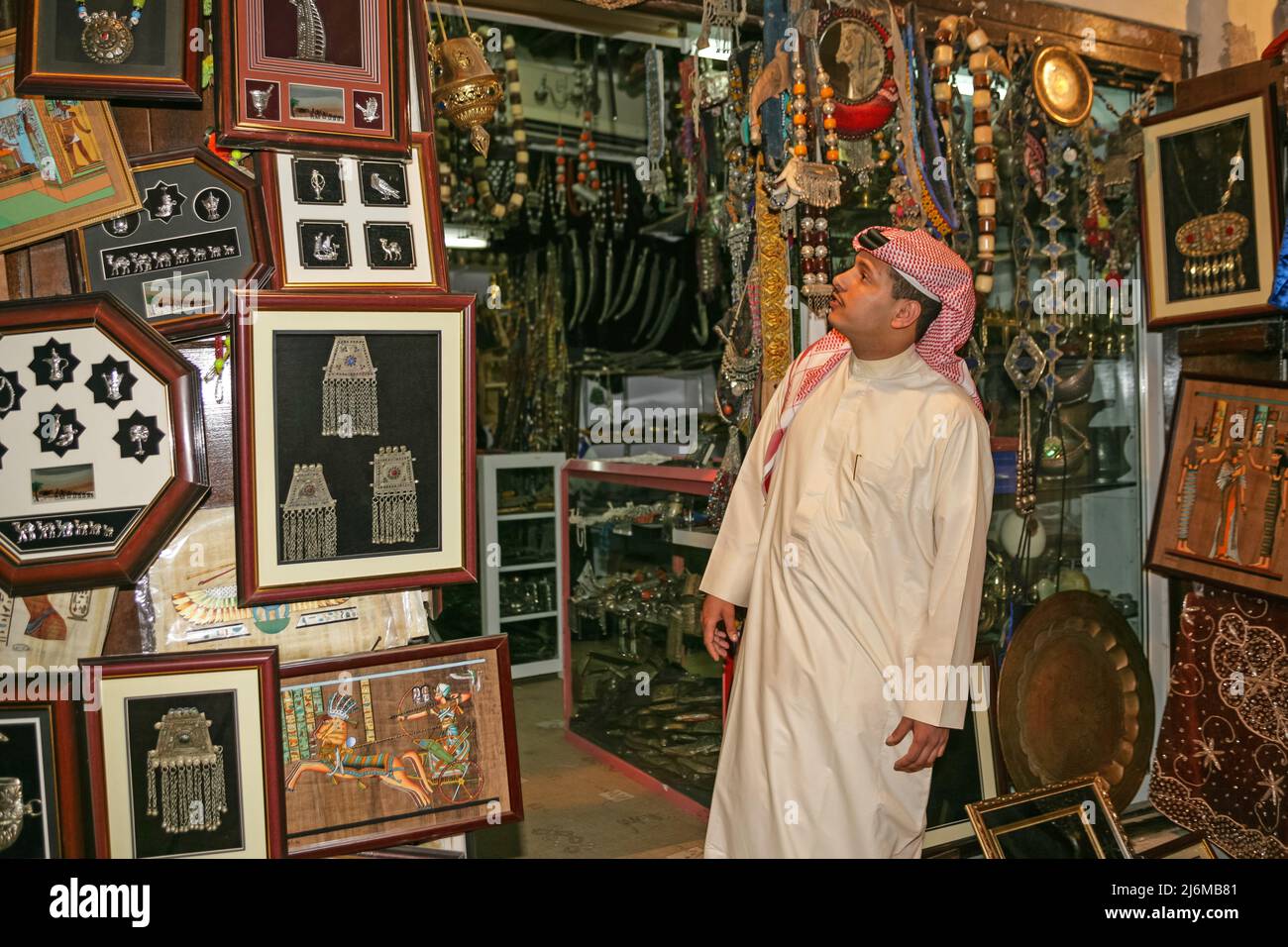 An Arab customer looking at curios in a shop in Sharjah's Heritage Area Souk in the United Arab Emirates. Stock Photo