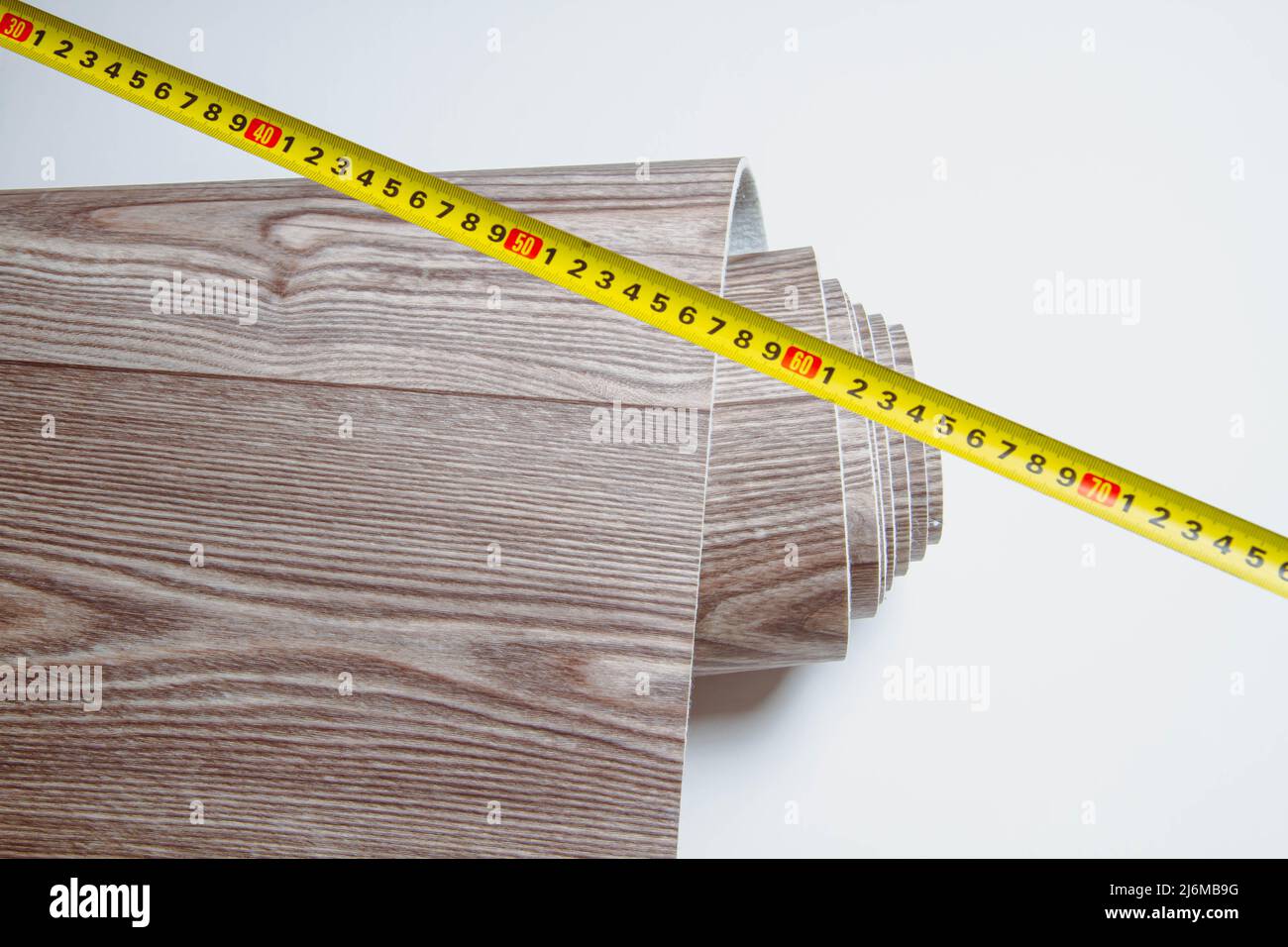 Measurement of linoleum on a cut. Man cuts linoleum. Tape measure and a