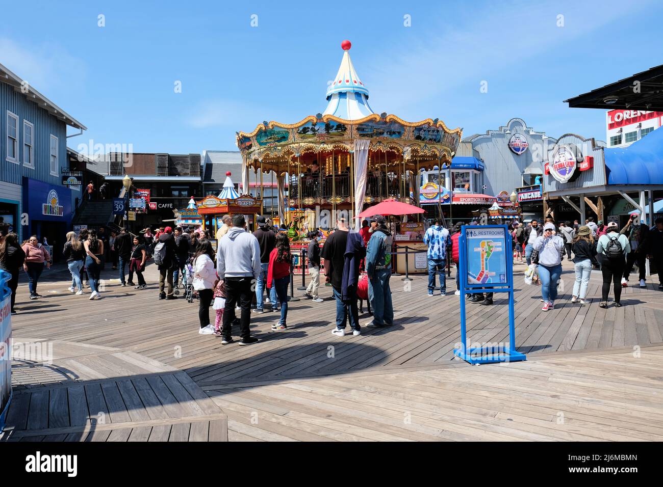 Carrousel, shops, and visitors at Pier 39 in San Francisco, California, USA on a sunny day; tourism and tourists in the Bay Area. Stock Photo