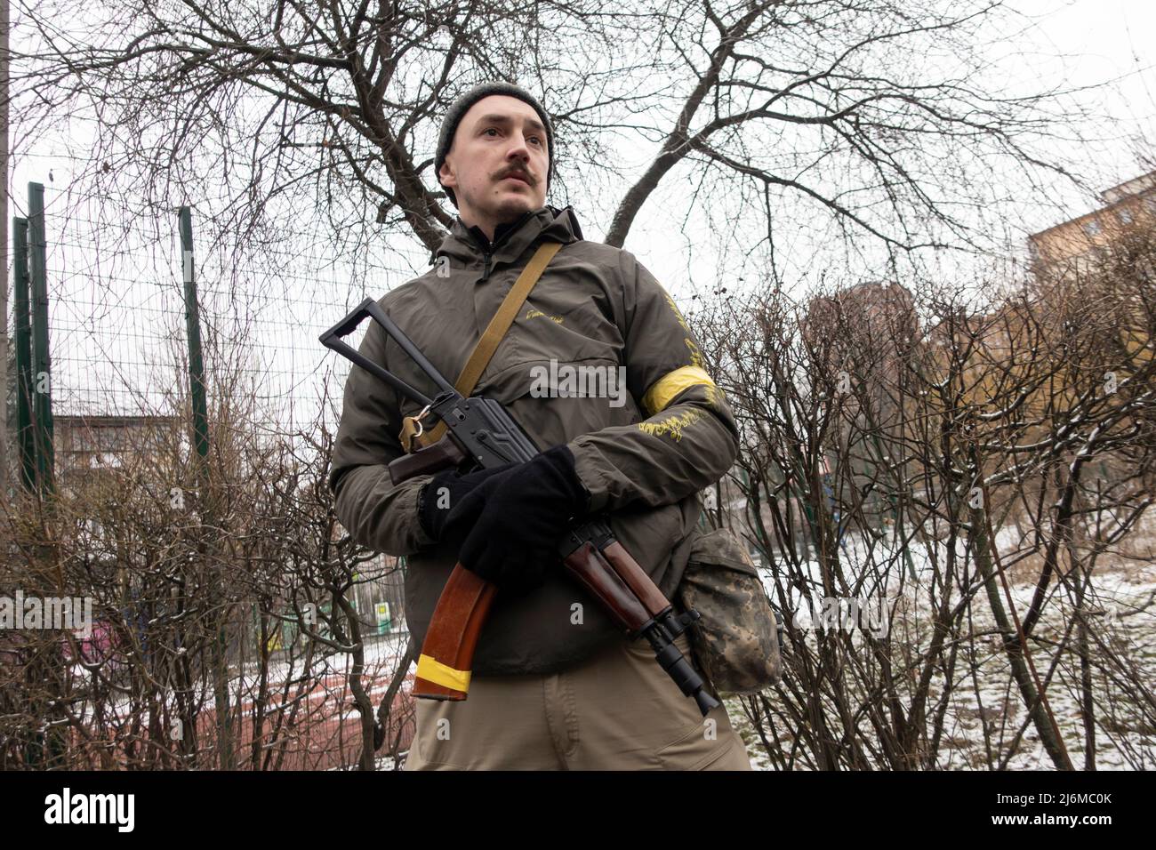 KYIV, UKRAINE 01 March. A member of the Territorial defense forces stands guard with a Kalashnikov rifle as Russia's invasion of Ukraine continues on 01 March 2022 in Kiev, Ukraine. Russia began a military invasion of Ukraine after Russia's parliament approved treaties with two breakaway regions in eastern Ukraine. It is the largest military conflict in Europe since World War II. Stock Photo