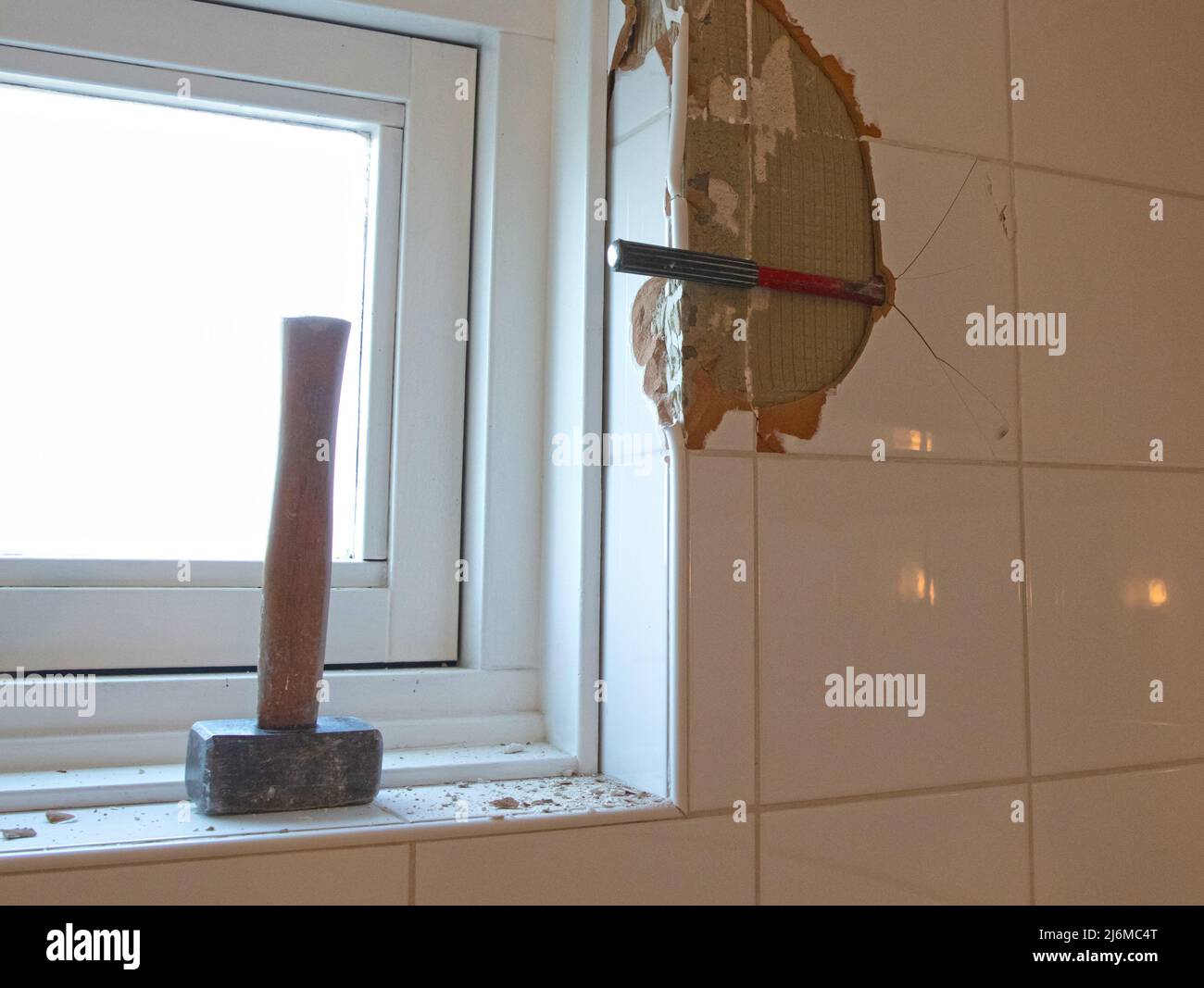 Breaking ceramic tiles, work in progress, maintenance Stock Photo Alamy