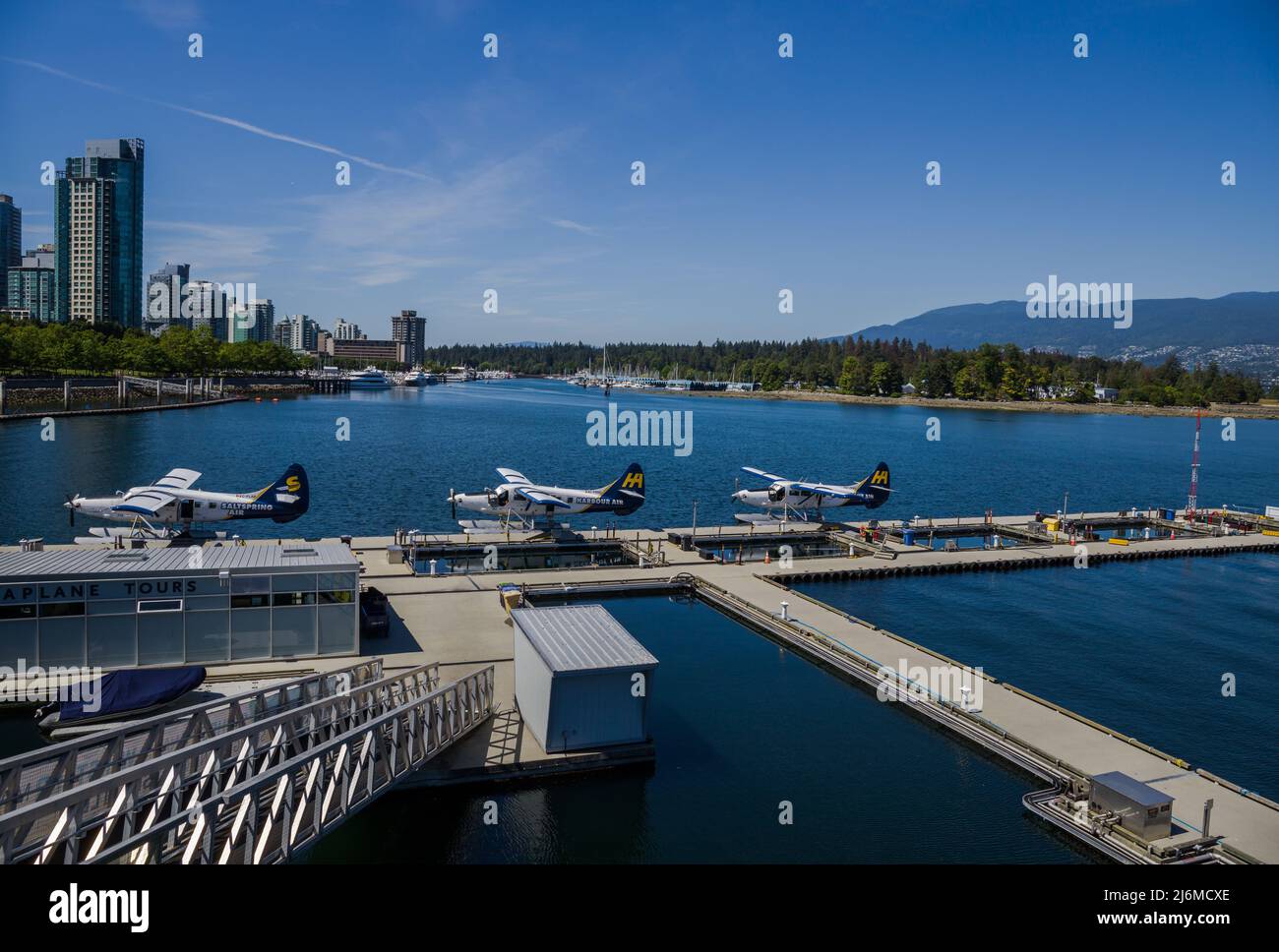 Vancouver, British Colambia - 16.08.2021 - Downtown water plane airport. Three planes staying in water. Stanley nature park background. Stock Photo
