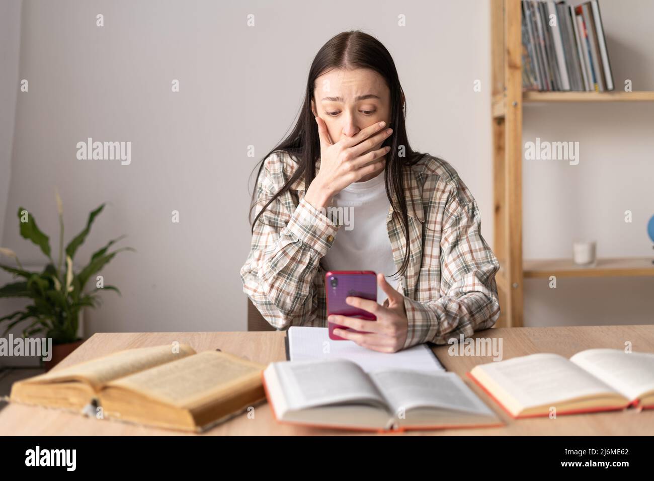 frightened young girl got bad news in social network message, addiction and cyberbullying, private message to teenager, virtual bullying Stock Photo