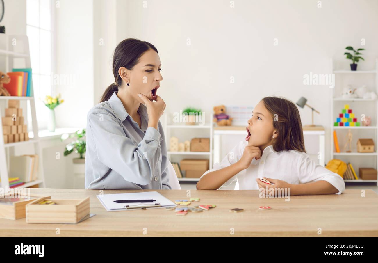 Child and speech therapist doing exercises to address certain pronunciation problems Stock Photo