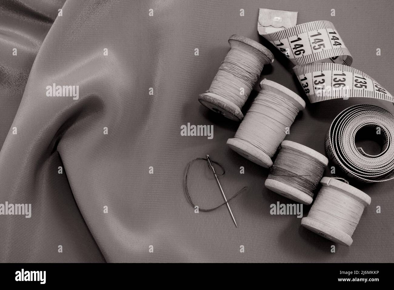 Vintage retro spool of thread on a black and white fabric background