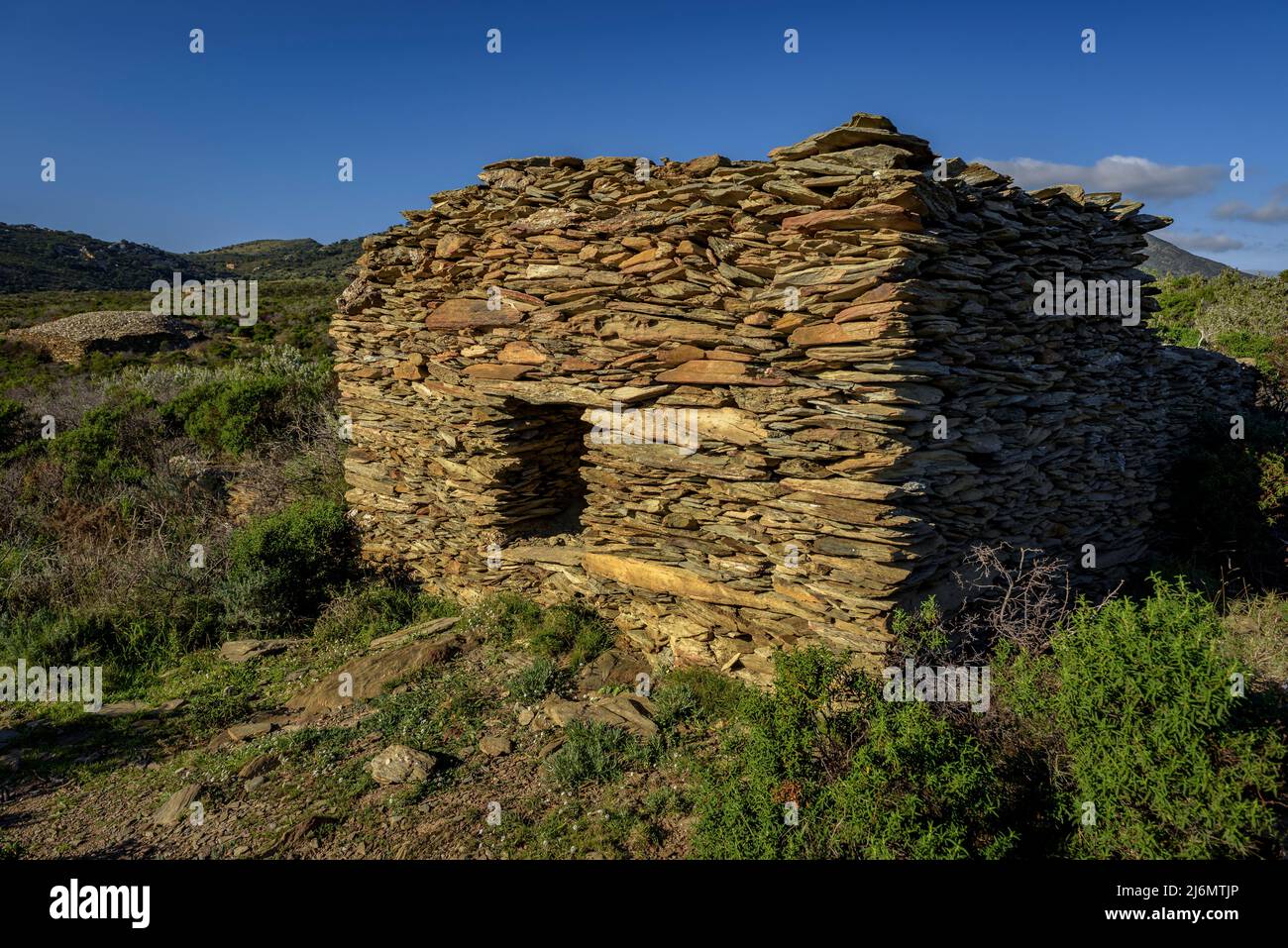Dry stone hut near the Cala Nans lighthouse, in Cap de Creus (Alt Empordà, Girona, Costa Brava, Catalonia, Spain) ESP Barraca de piedra seca en España Stock Photo