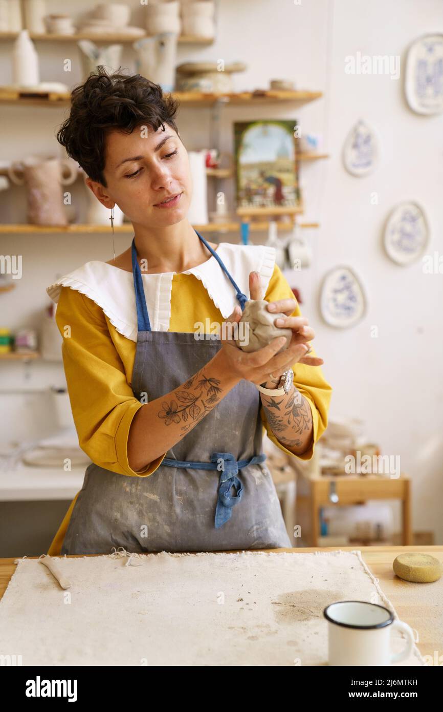 Female pottery owner enjoy working with raw clay. Artist woman
