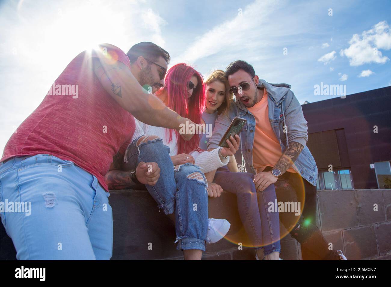 group of four young friends having fun with a phone Stock Photo