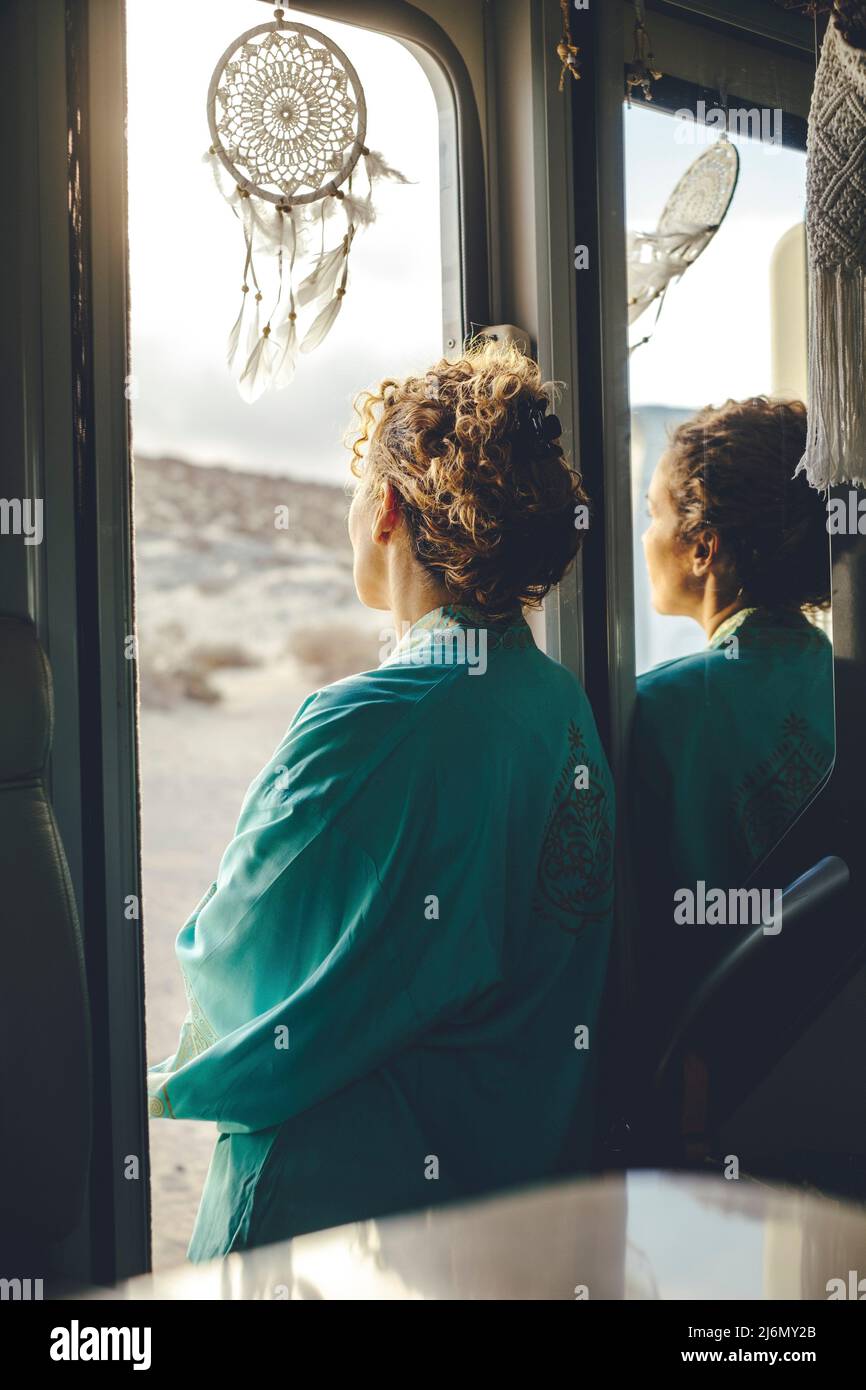 Thoughtful standing back view of lady looking outdoors standing on camper van door. Concept of alone traveler and loneliness. Alternative free Stock Photo