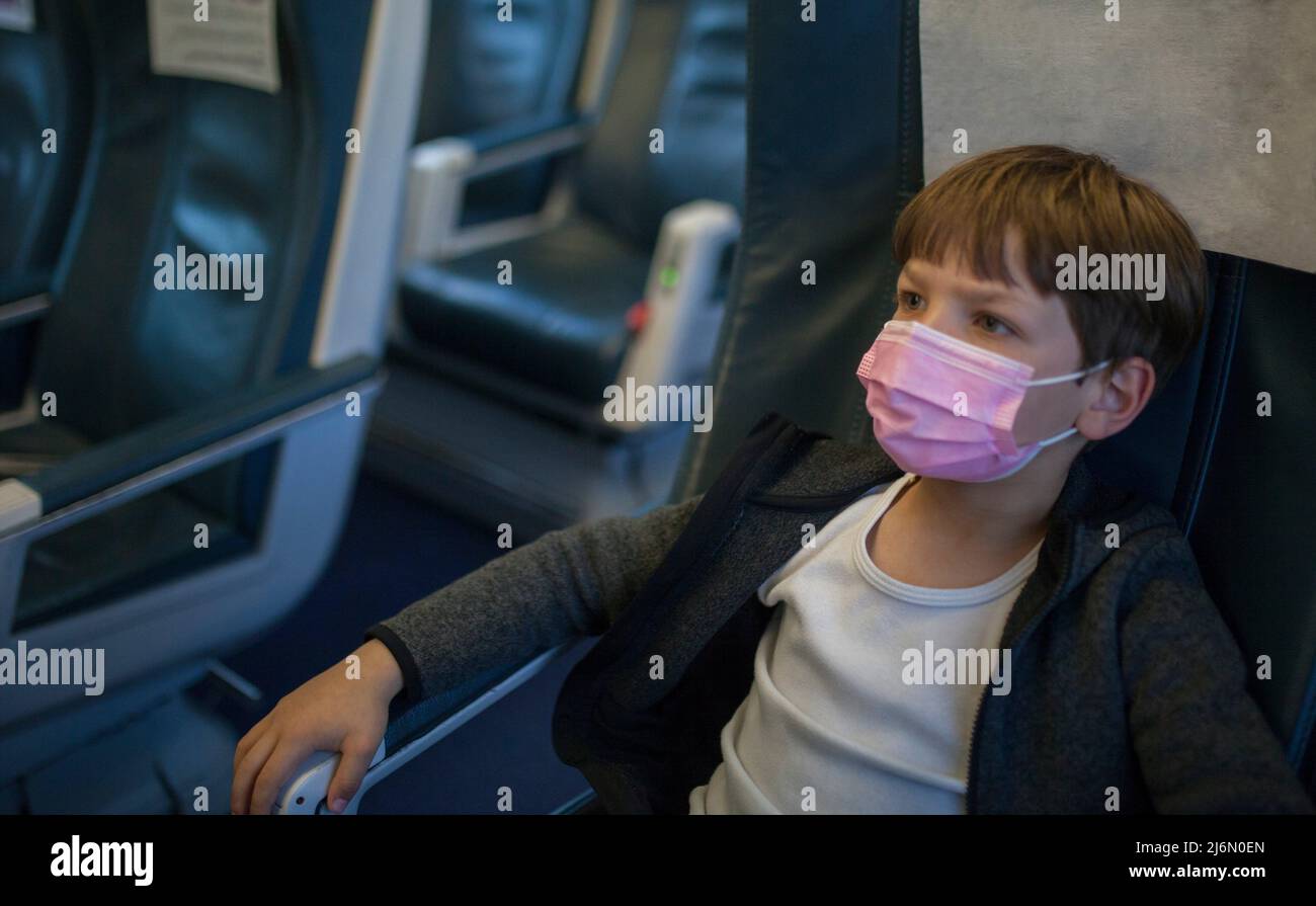Child traveling by train comfortably. He is watching tv. Stock Photo