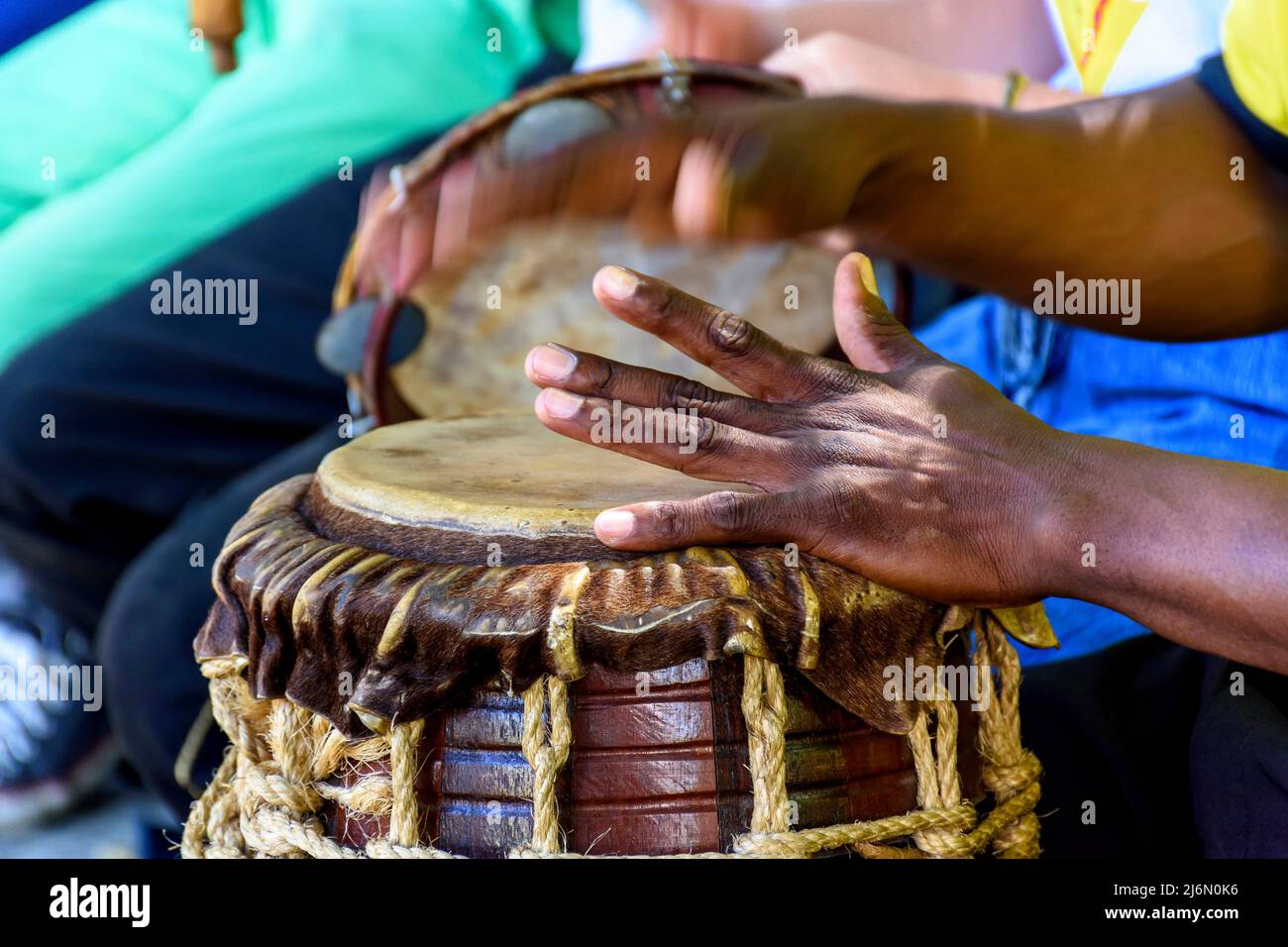 Musician playing a rudimentary percursion instrument called atabaque during afro-brazilian capoeira cultural manifestation. Stock Photo