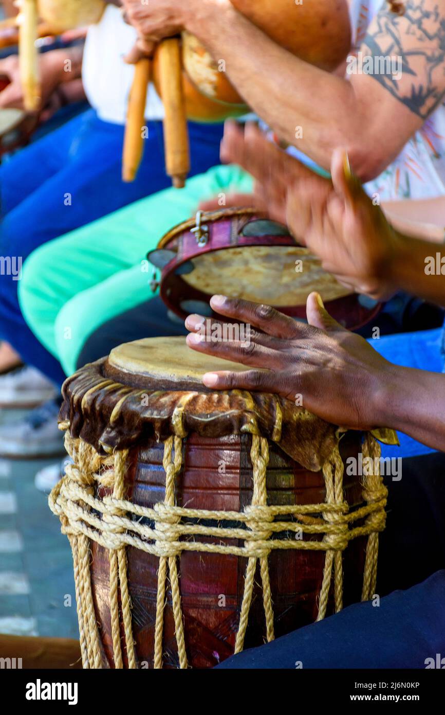 Percussionist playing a rustic and rudimentary percursion instrument atabaque during afro-brazilian cultural manifestation. Stock Photo