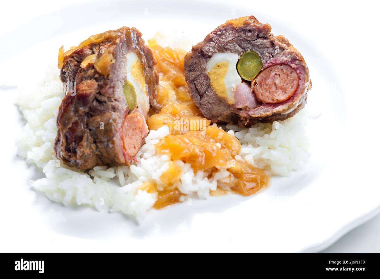 beef roulade filled with egg, sausage, bacon and prickle served with rice. Stock Photo