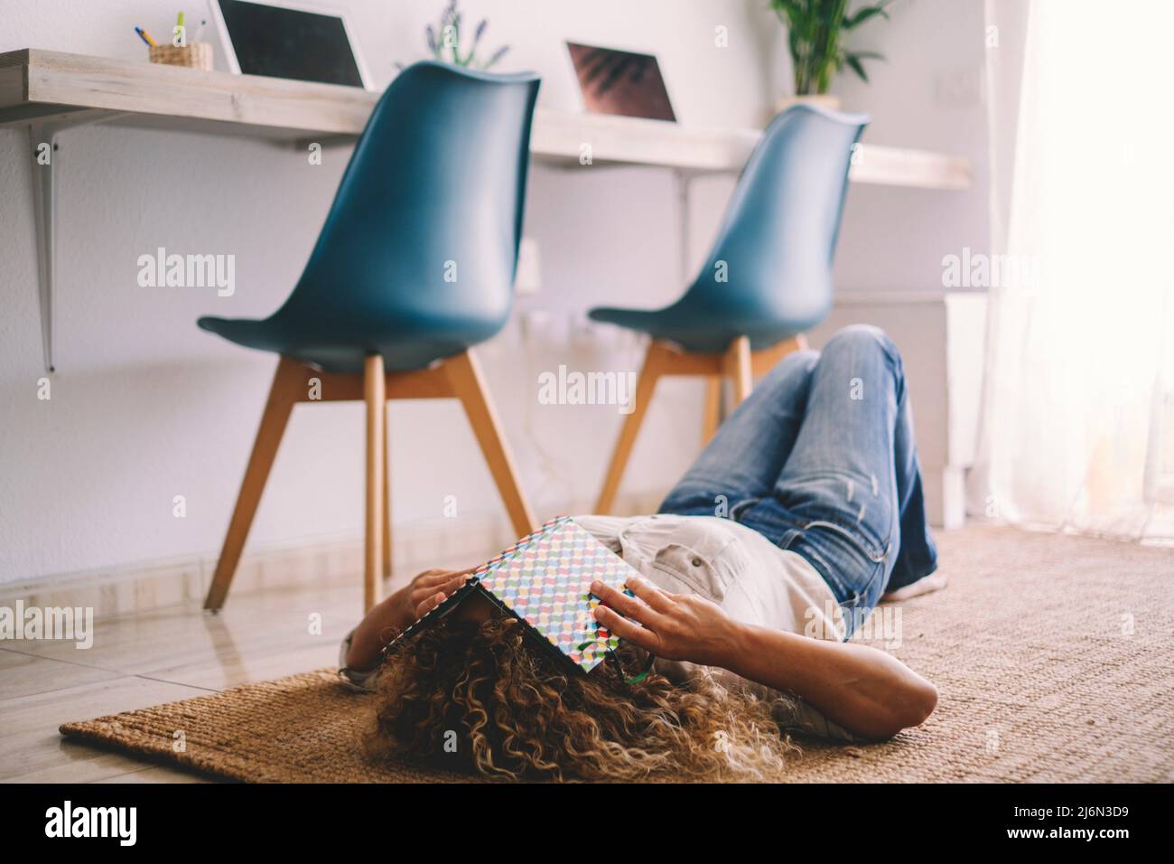 Young woman asleeping on the carpet at home with workstation computer