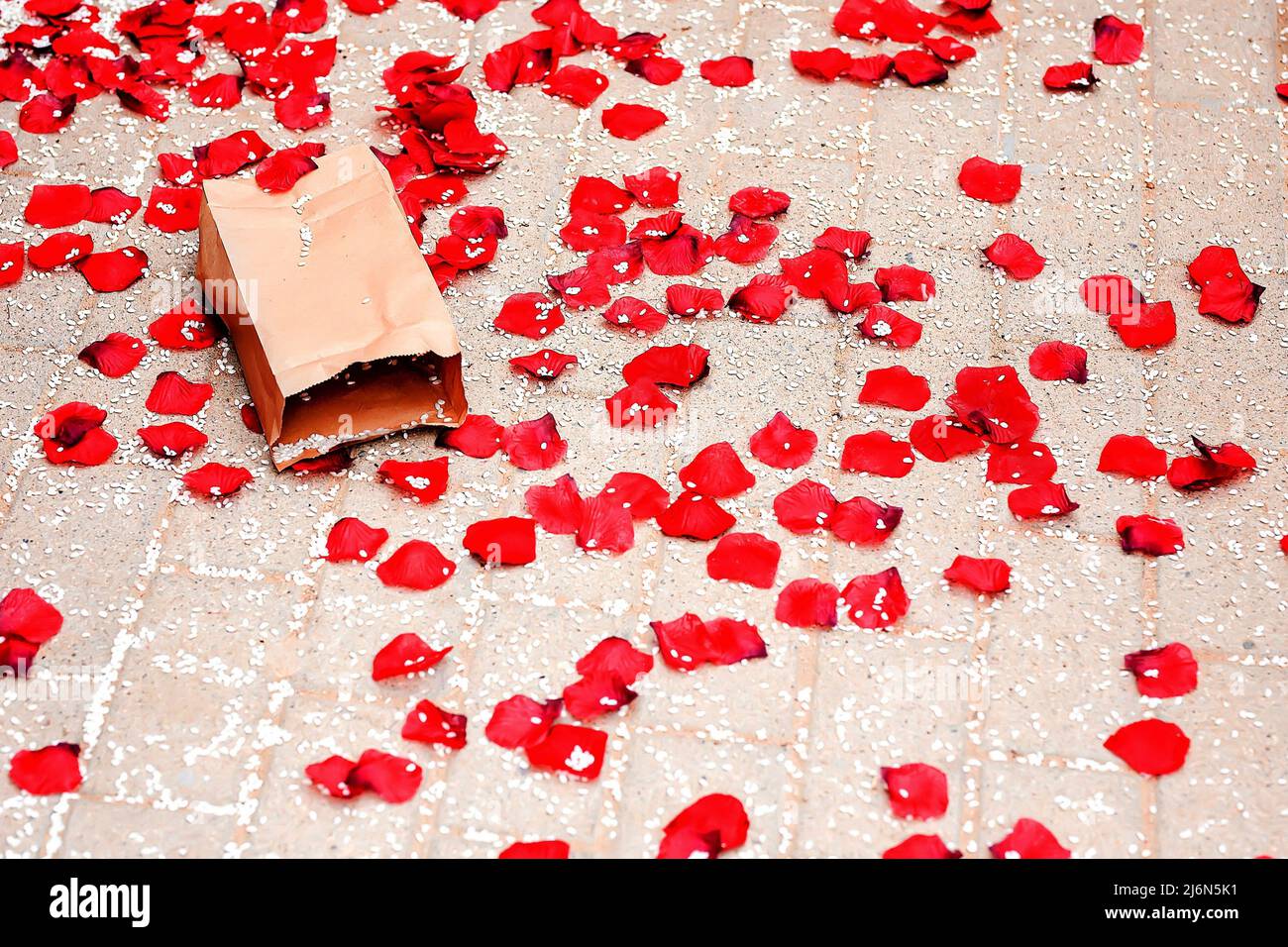 Paper bag containing rice and petals on the ground thrown at a wedding
