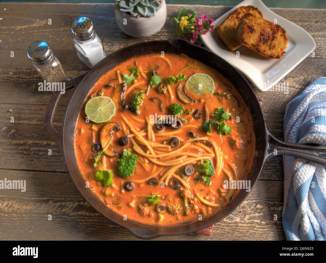 Top view of Red Thai Curry Noodle Soup on Natural Wood Table. Stock Photo