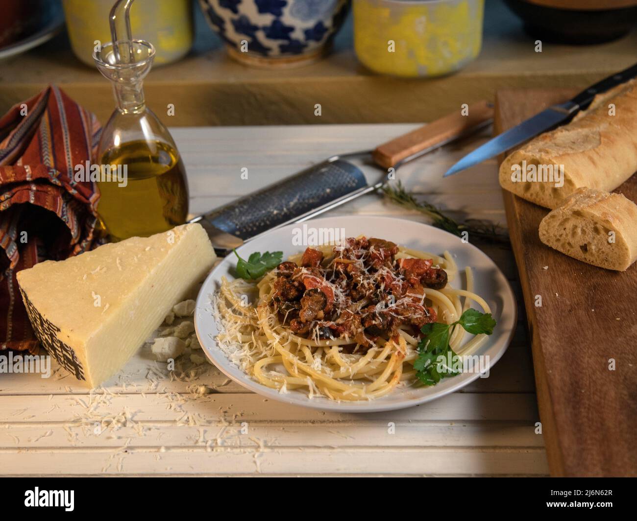 Bucatini Bolognese Pasta Dish eith bread and cheese top view on white table. Stock Photo