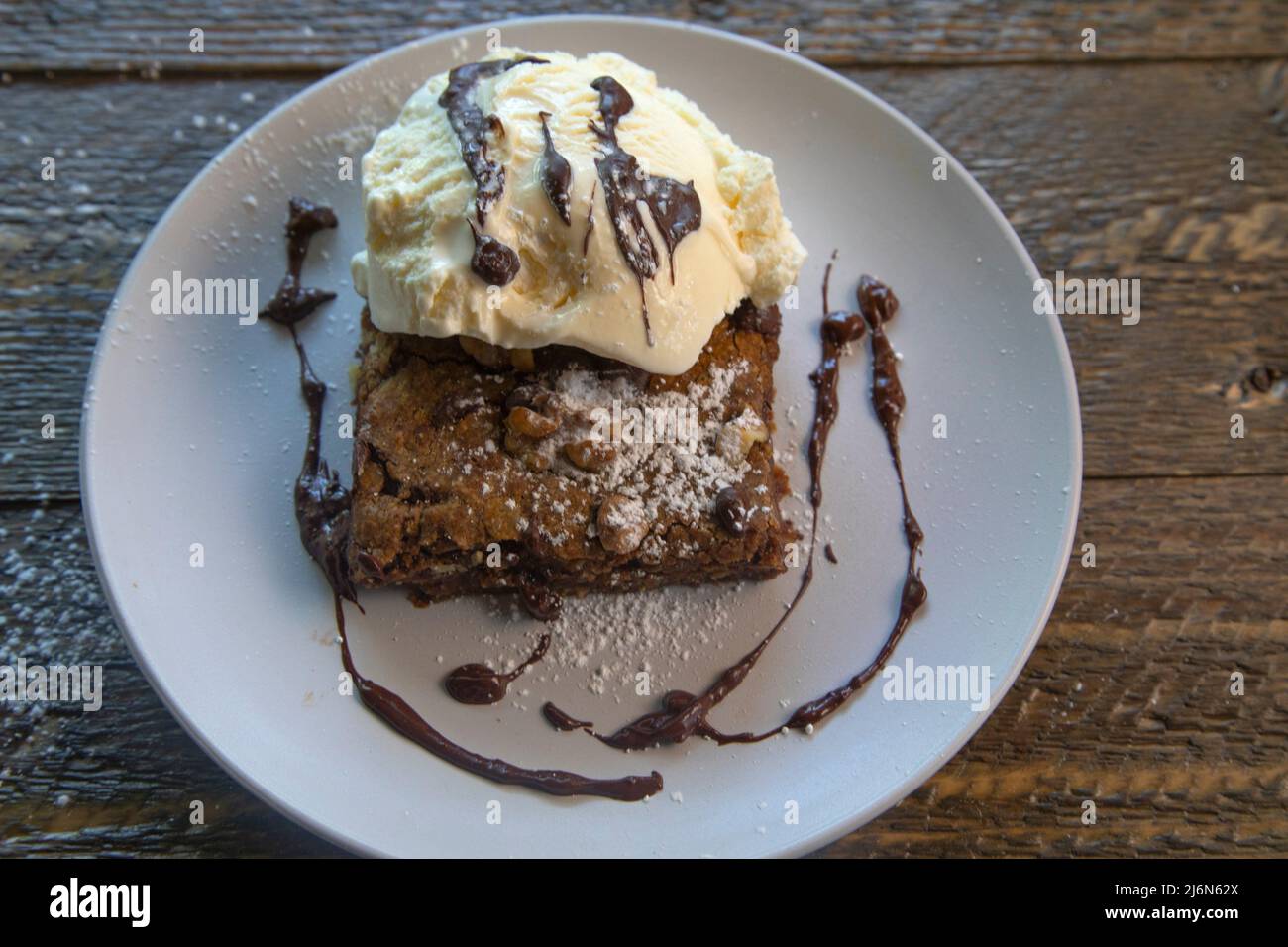 Top view of vanilla ice cream on a brownie on natural wood table. Stock Photo