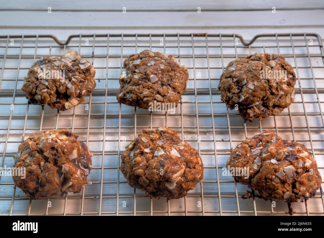 Side view of chocolate, coconut oatmeal cookies on wire coolong rack. Stock Photo