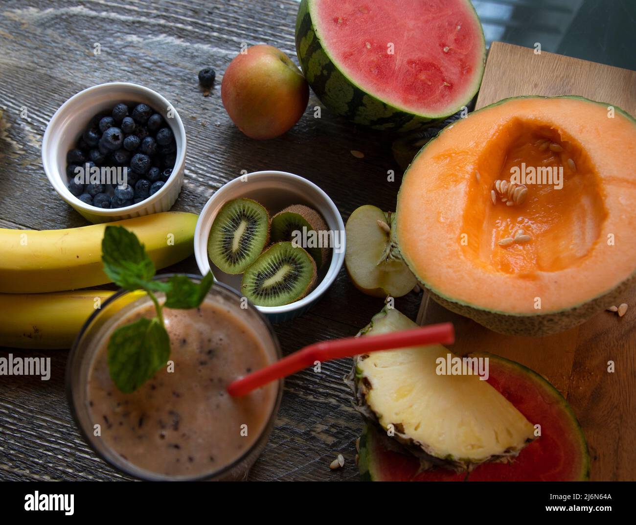 Top view of smoothie with fresh fruit on natural wood table. Stock Photo