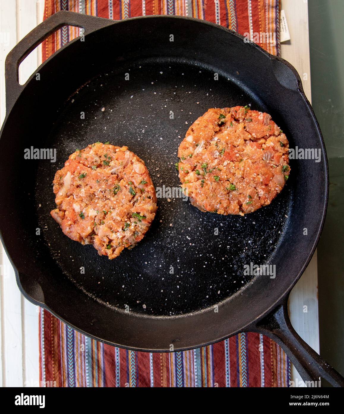 Top View of Seasoned Raw Salmon Patties on white wooden table. Stock Photo