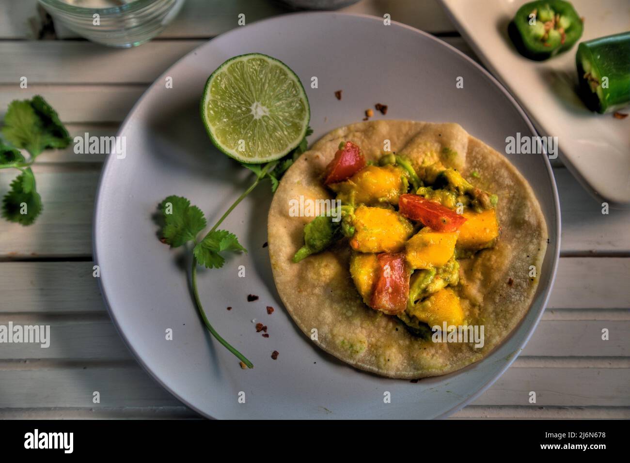 Top view of tacos with mango, avocado, jalapeno, tomato and red onion. Stock Photo