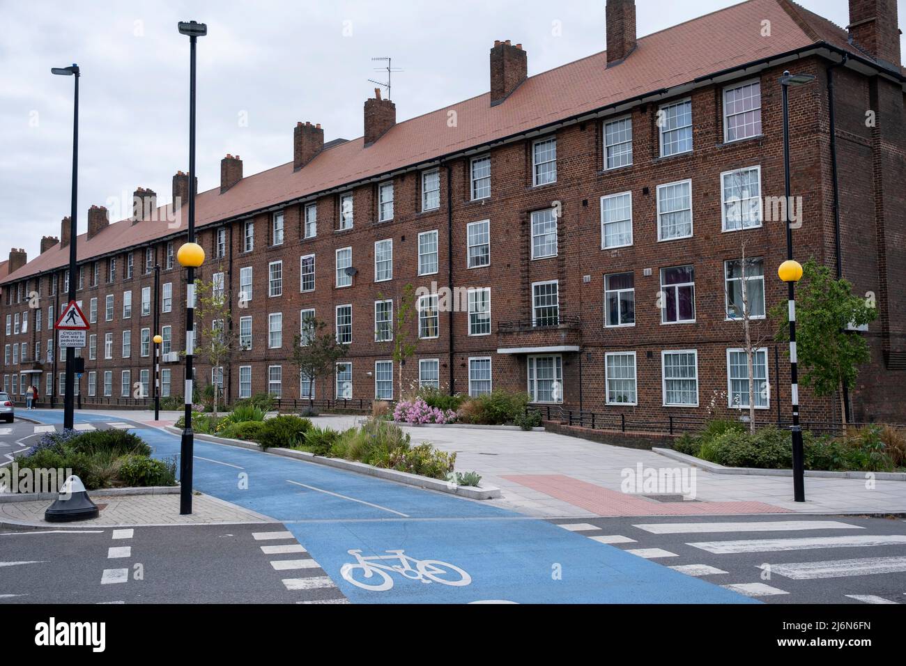 Cycle lane beside social housing block in Shadwell on 27th April 2022 in London, United Kingdom. Cycle Superhighway 3 or CS3 is a long cycle path and part of the Cycleway network coordinated by TfL. It runs from east to central London. It is a popular route with both commuter and leisure cyclists, passing a number of major destinations in London along its route. For almost the entire route, cyclists are separated from other traffic in segregated cycle lanes, and cycling infrastructure has been provided at major interchanges. CS3 has now been renamed to Cycleway 3 or C3. Council estates like th Stock Photo