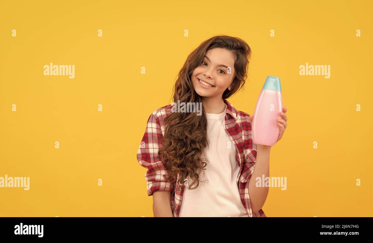 beauty. kid use shower gel. happy teen girl with shampoo bottle
