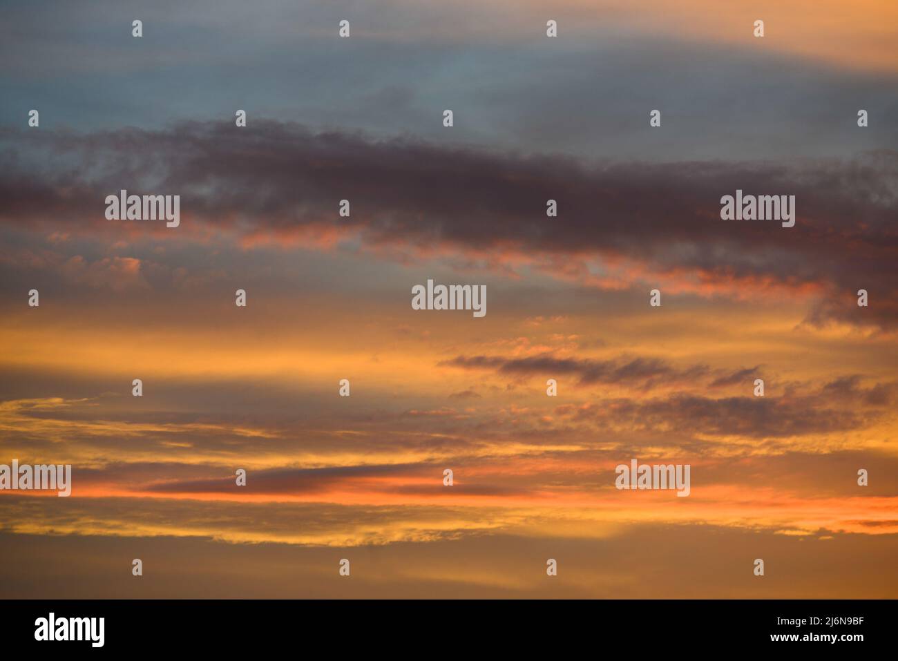 Sky with colorful orange and yellow clouds at sunset with space for text Stock Photo