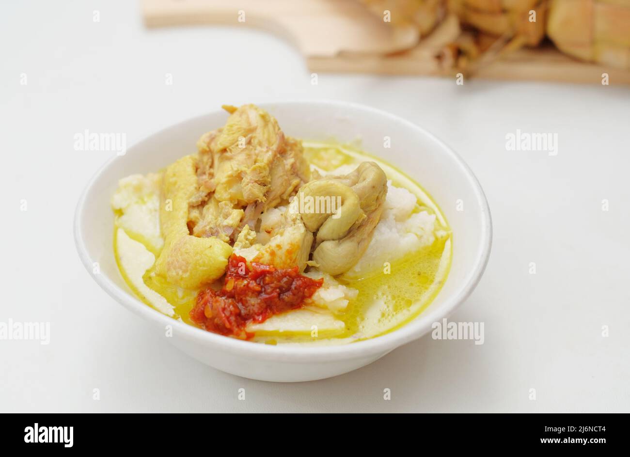 Opor Ayam is served on a white background. Opor is a traditional Indonesian food made from chicken cooked with coconut milk sauce Stock Photo