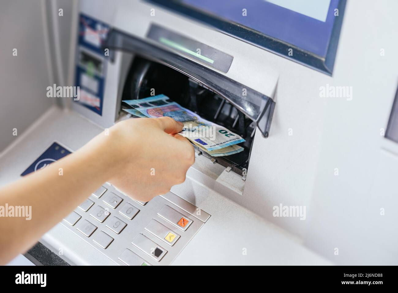 Close up of a woman's hand withdrawing cash, euro bills from the ATM bank machine. Finance customer and banking service concept Stock Photo