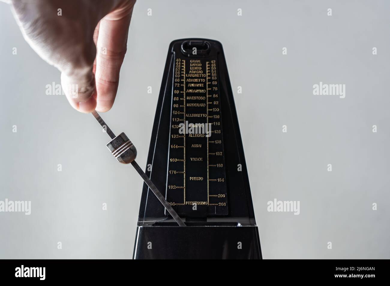 Swings a metronome with a hand Stock Photo
