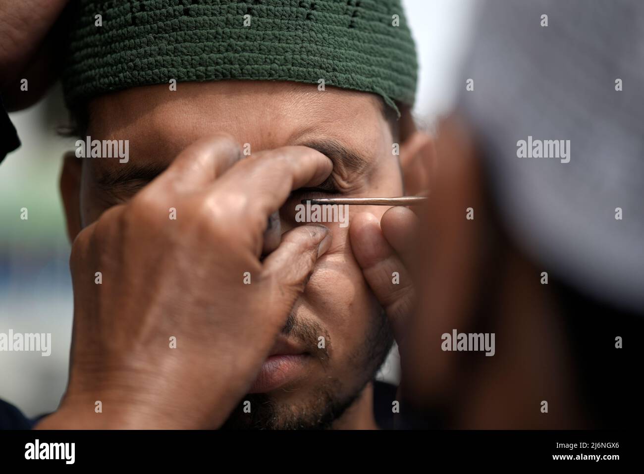 Guwahati, Assam, India. 03rd May, 2022. A Muslim man applying Surma on eyes before offer prayer at a Eidgah to start the Eid al-Fitr festival, which marks the end of their holy fasting month of Ramadan, in Guwahati, Assam, India on May 03, 2022. Credit: David Talukdar/Alamy Live News Stock Photo