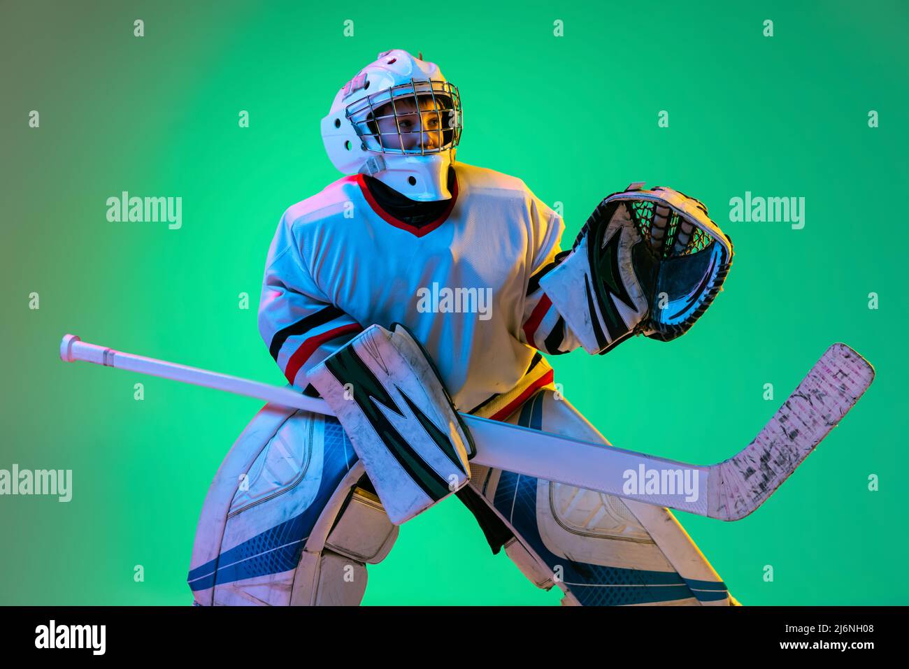 Dynamic portrait of teen boy, hockey player, goalkeeper catching puck