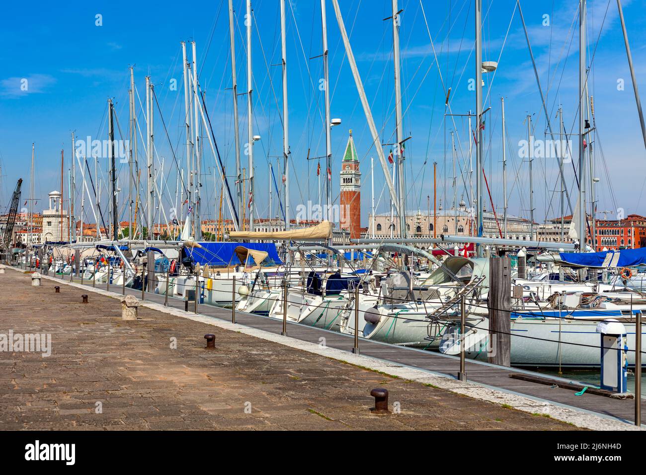 San Marco Campanile as seen through the masts of white yachts moored at small marina on San Giorgio Maggiore island in Venice, Italy. Stock Photo